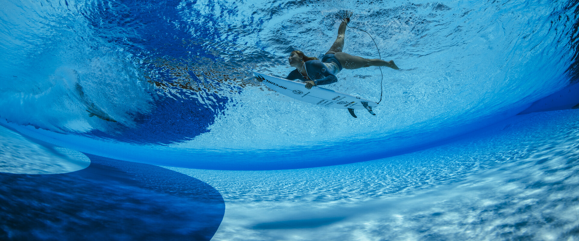 Im derzeit gr&ouml;&szlig;ten Wellenpark Europas kannst du das ganze Jahr &uuml;ber surfen. Das Bild zeigt eine Surferin beim Duckdive unter eine k&uuml;nstlichen Welle hindurch.